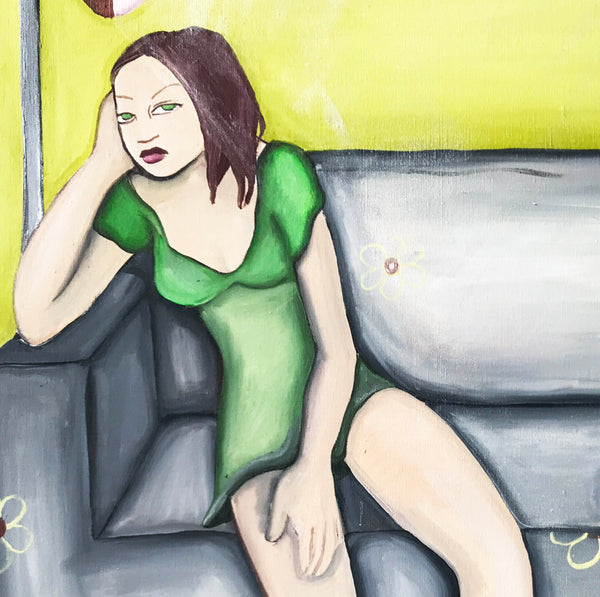 Girl in Green Dress on Grey Sofa with Fallen Vase